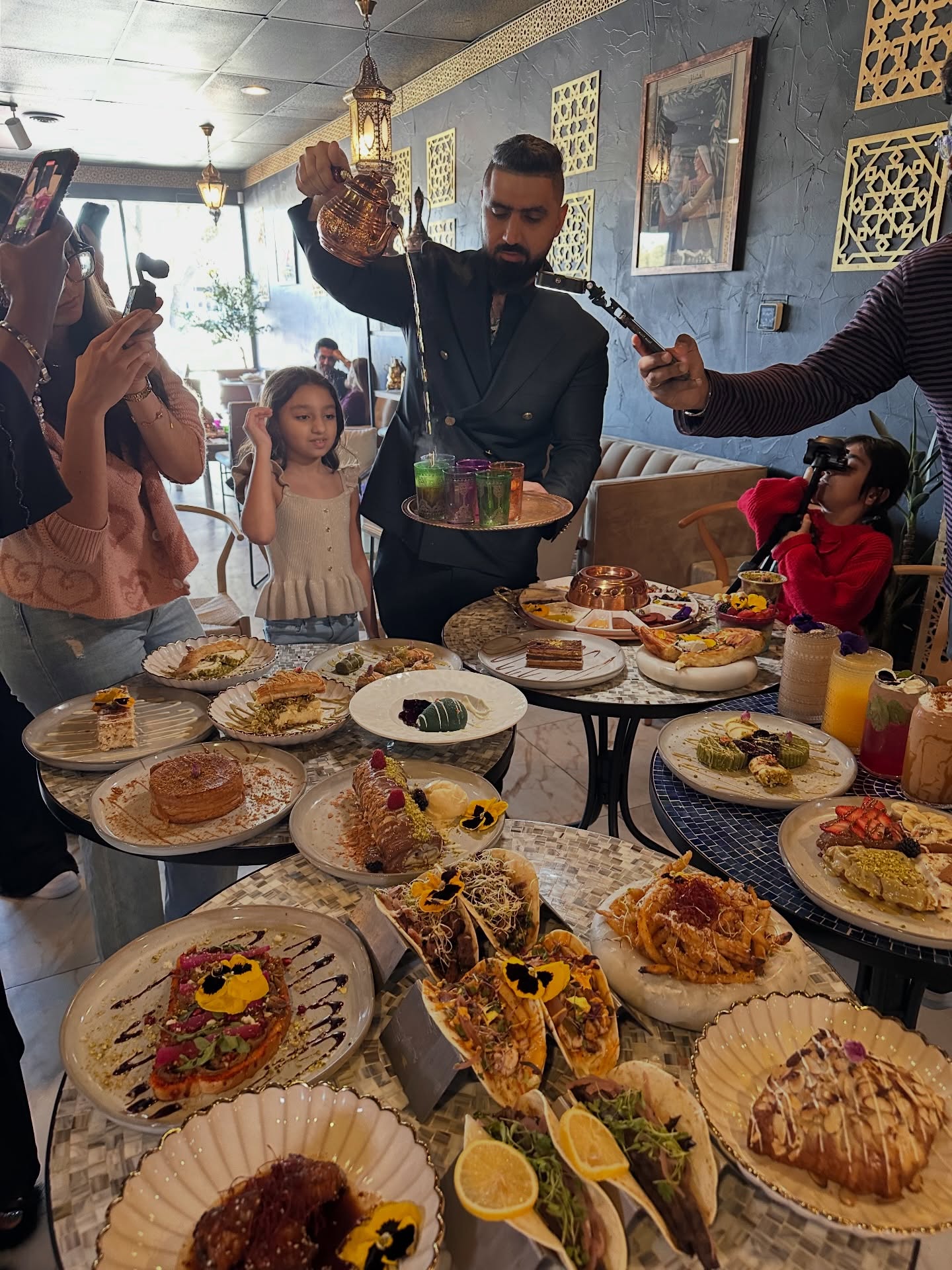Peace Middle East hospitality table with family, desserts, tea, and cafe moments